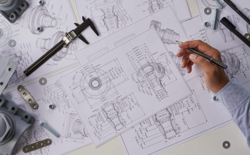 Ingeniero revisando dibujos técnicos y archivos del proyecto para evaluación RFQ